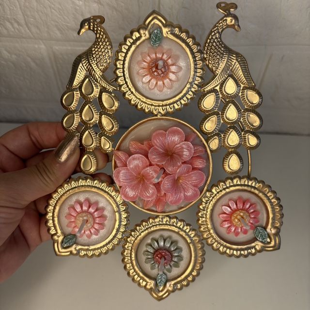 DH-02: Twin peacocks in gold metal, holding five flower candles, held in a hand, to show its size.
