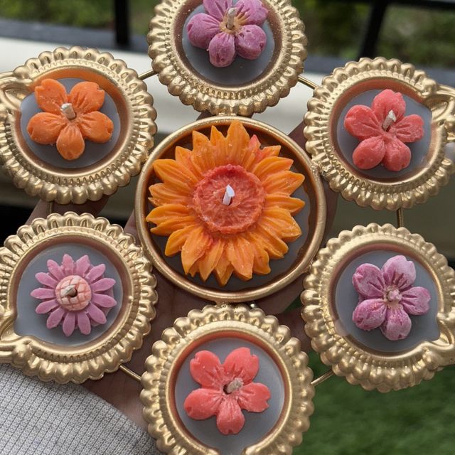 DH-03: Six flower diyas around one big orange bloom, joined in a gold metal frame, close-up of the flower diyas.