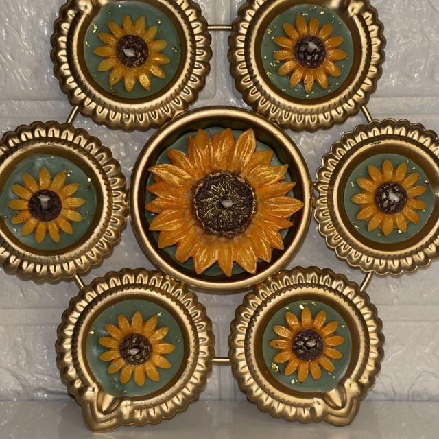 DH-04: Six sunflower diyas around one big sunflower, joined in a gold metal frame, close-up of the sunflowers.