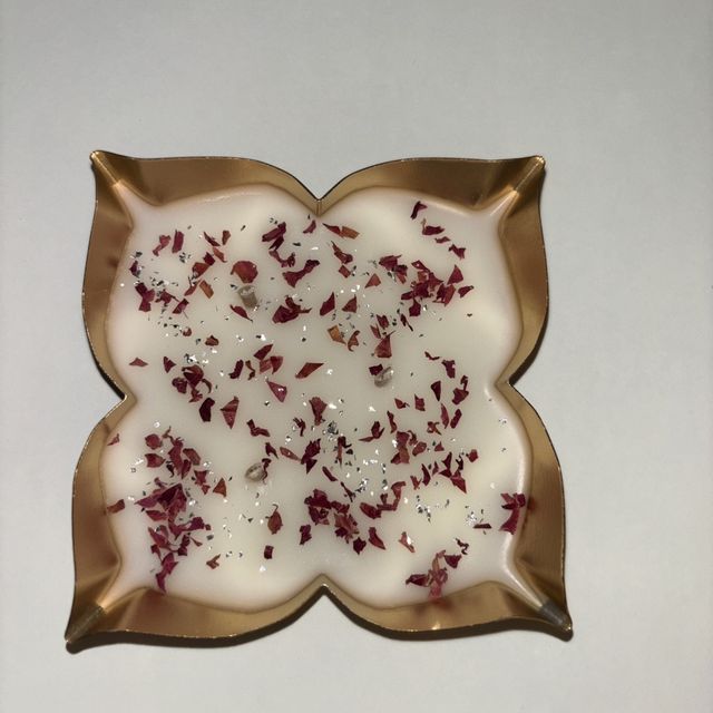 DH-12: Rose petals set in white wax, in a four-point gold metal tray, from above.
