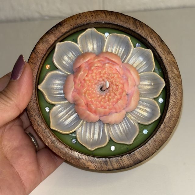 DH-13: A peach lotus on green wax, in a round wooden bowl, held in a hand, to show its size.