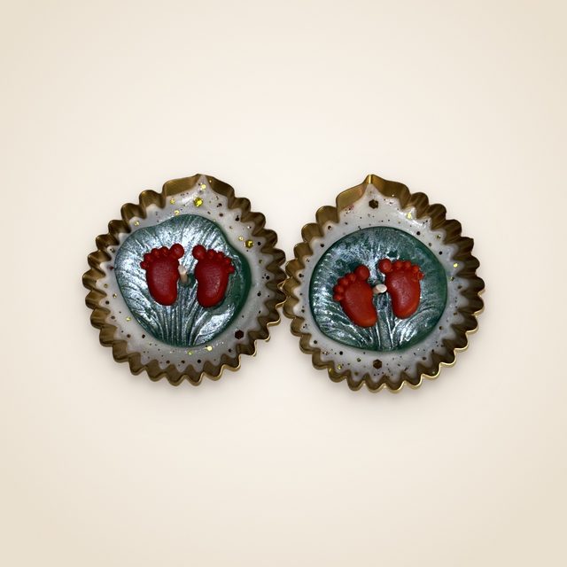 DH-16: A pair of diyas with Lakshmi’s footprints, in scalloped gold metal cups.